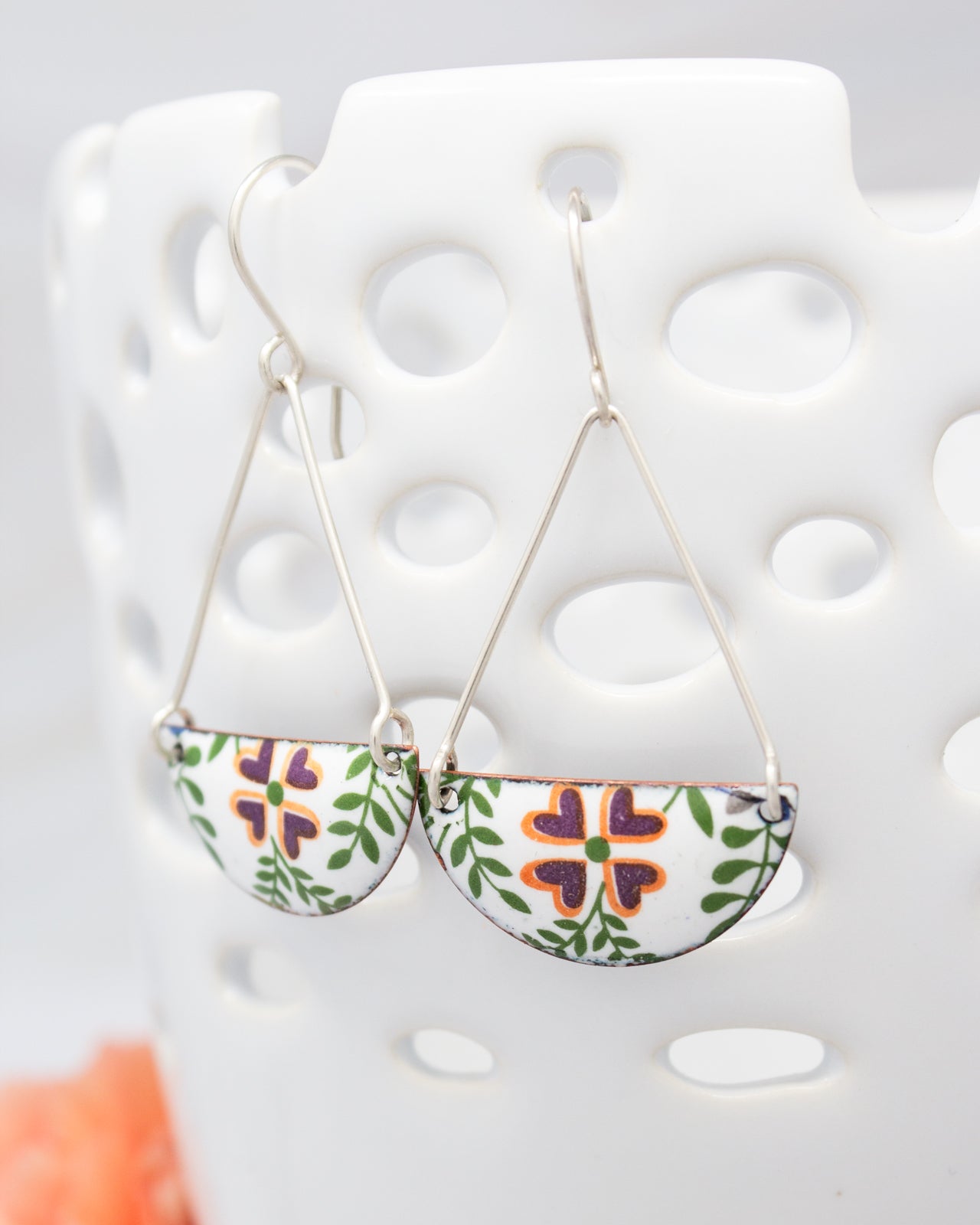A pair of earrings with a floral design on a white background.