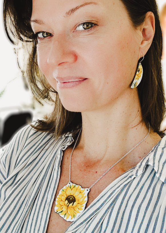 a woman with a sunflower necklace and earrings