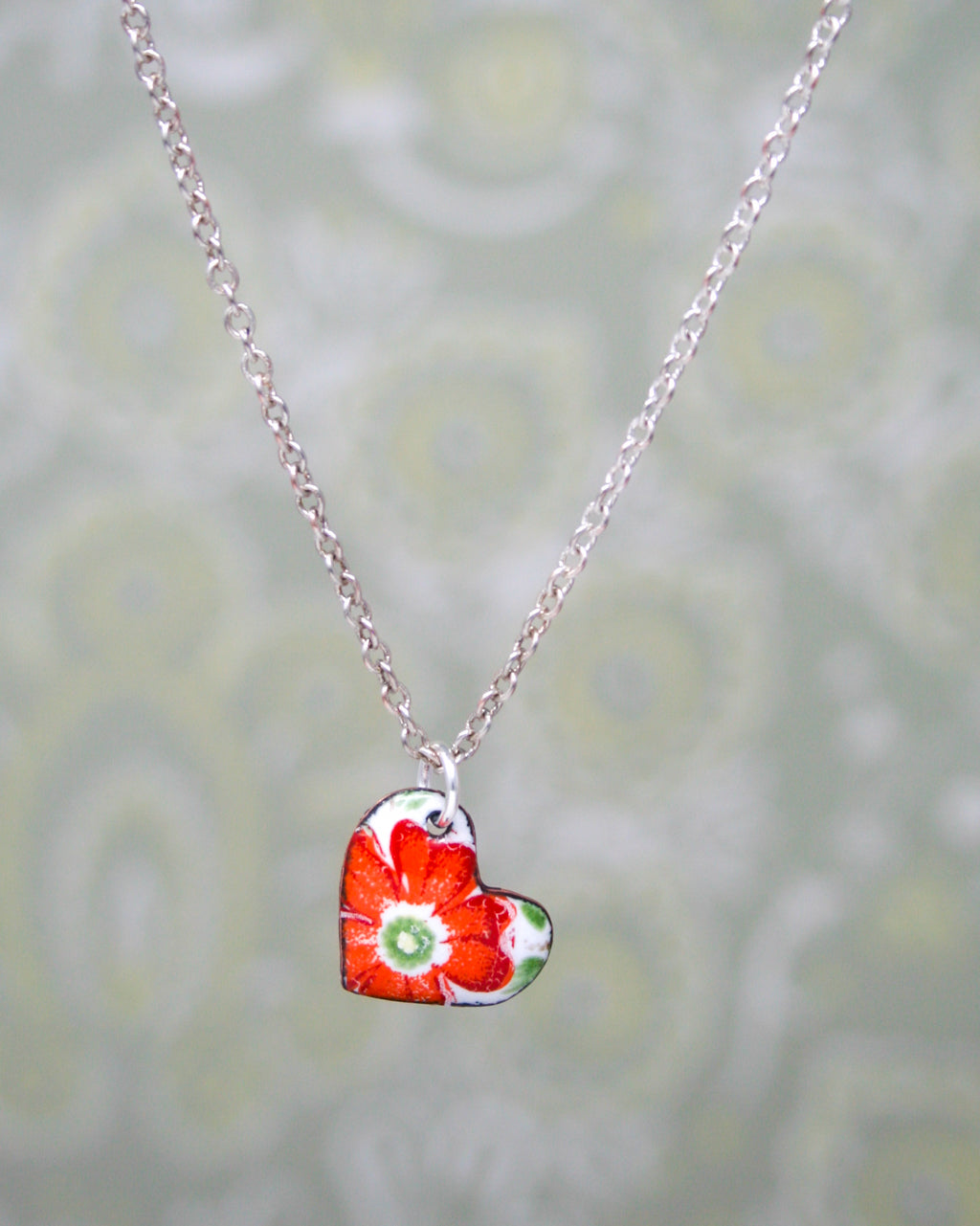 a heart shaped necklace with a flower on it