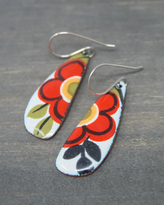 a pair of earrings with flowers painted on them