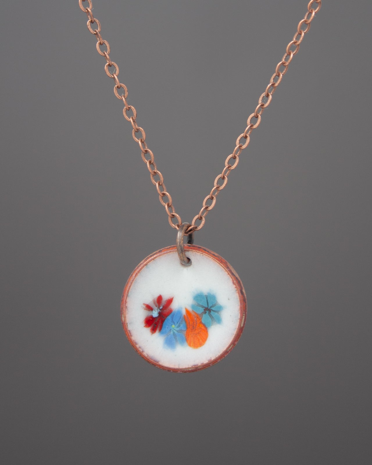 A necklace with a circular pendant featuring a floral design.