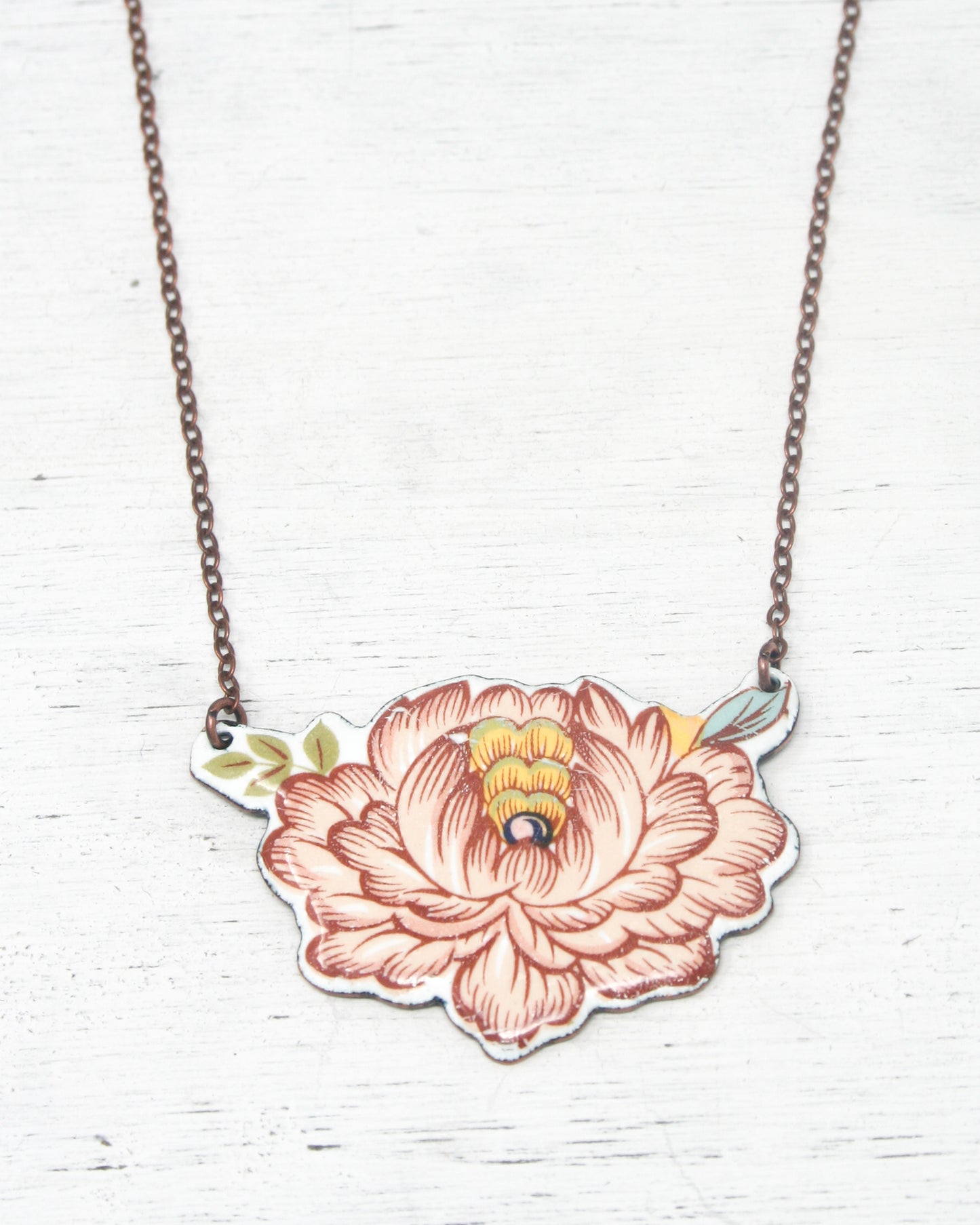 a necklace with a flower and a bird on it