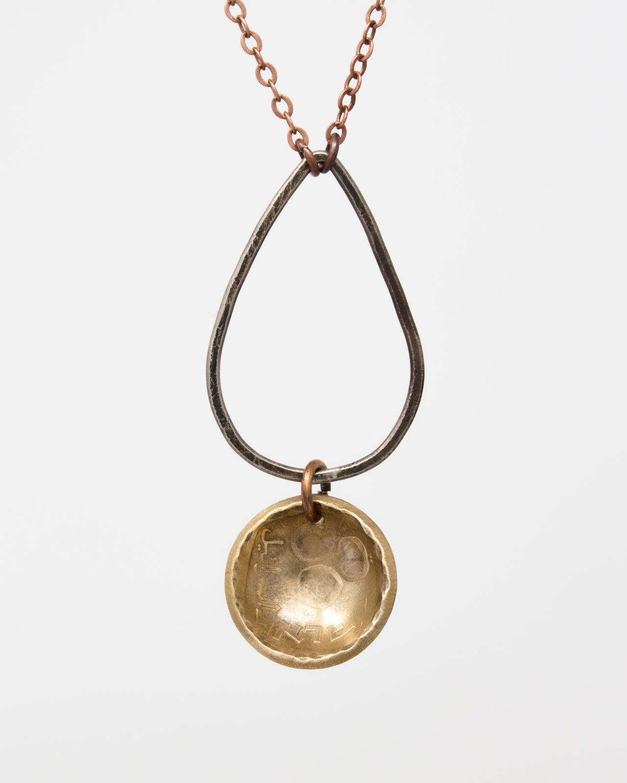 A necklace with a pendant featuring a small, round, metallic object hanging from a chain.