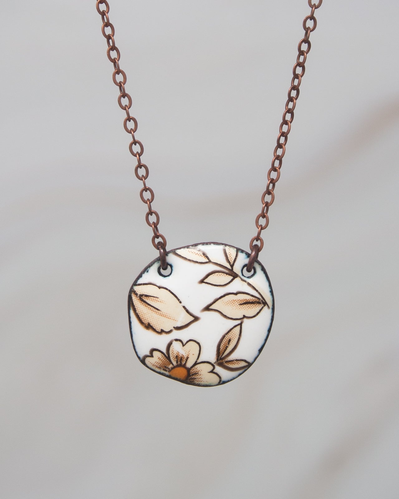 A necklace with a circular pendant featuring a floral design.