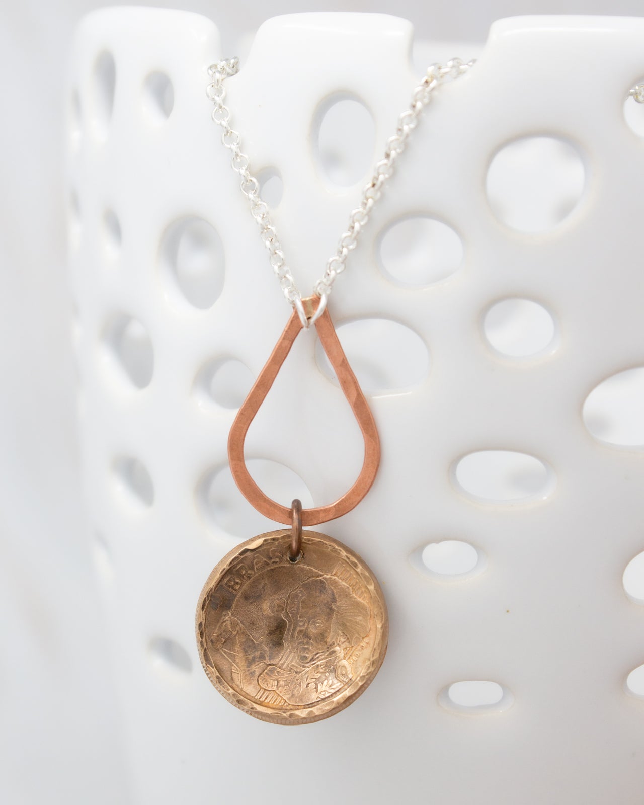 A necklace with a pendant featuring a circular design, hanging from a chain.