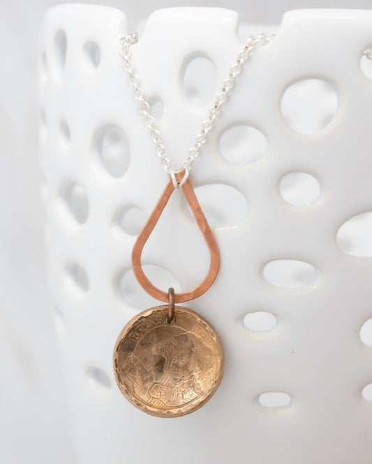 A necklace with a pendant featuring a circular design, hanging from a chain.