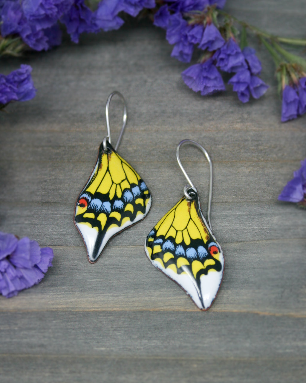 a pair of yellow and white butterfly earrings