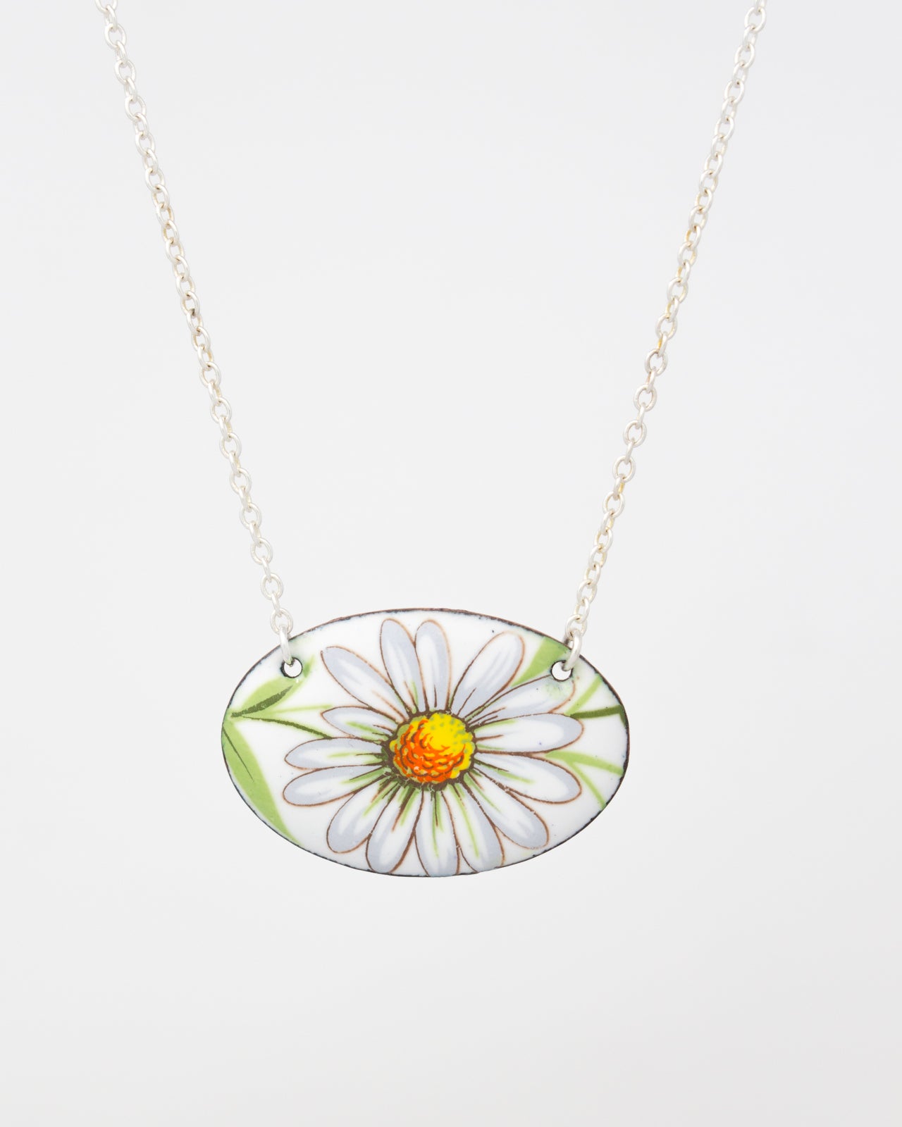 A necklace with a pendant featuring a white daisy flower with a yellow center.