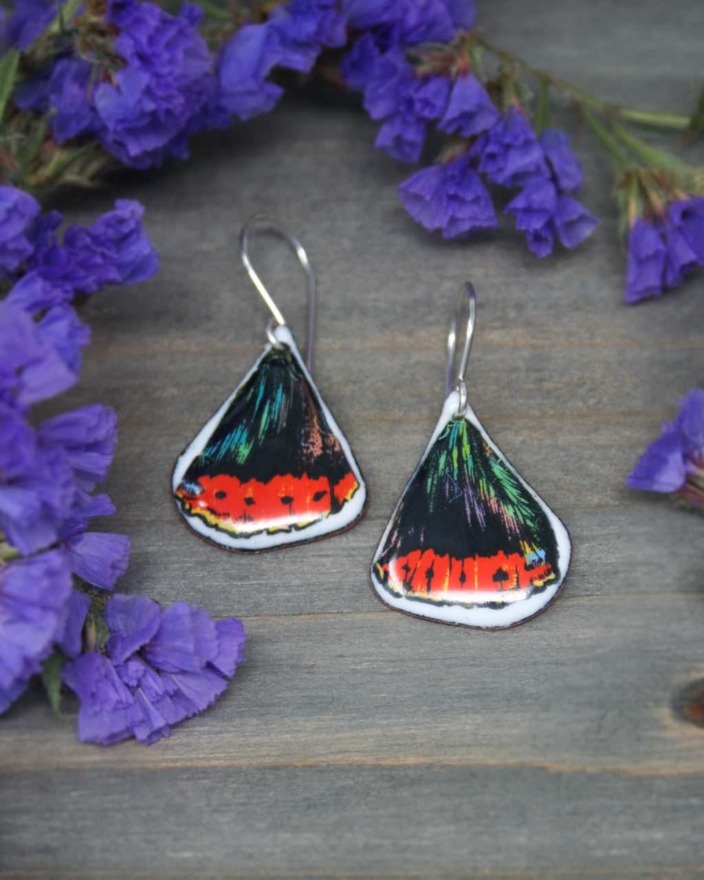 a pair of earrings with a picture of a butterfly on them