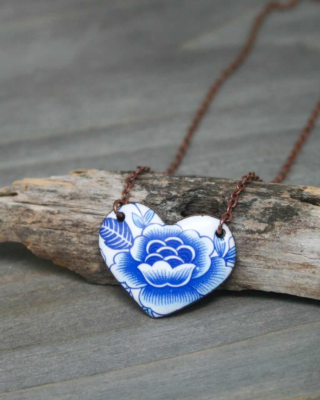 a blue and white flower on a brown chain