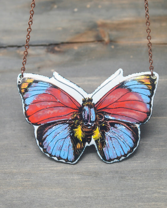 a colorful butterfly is hanging from a chain