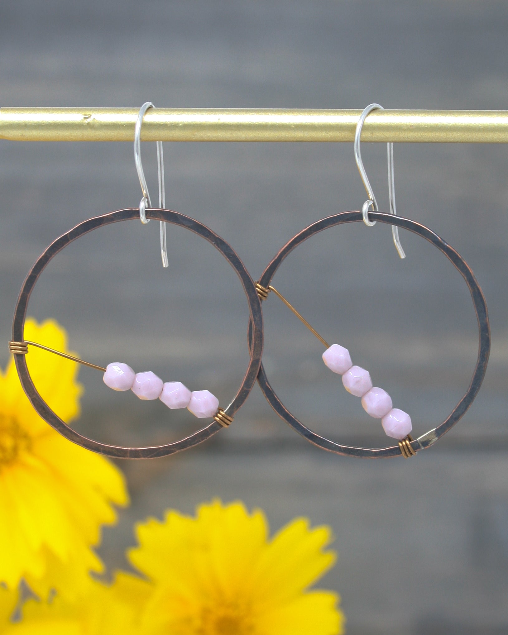 a pair of hoops with beads hanging from them