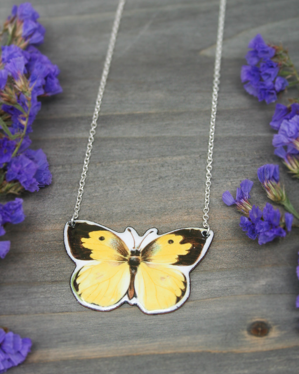 a yellow and black butterfly on a silver chain