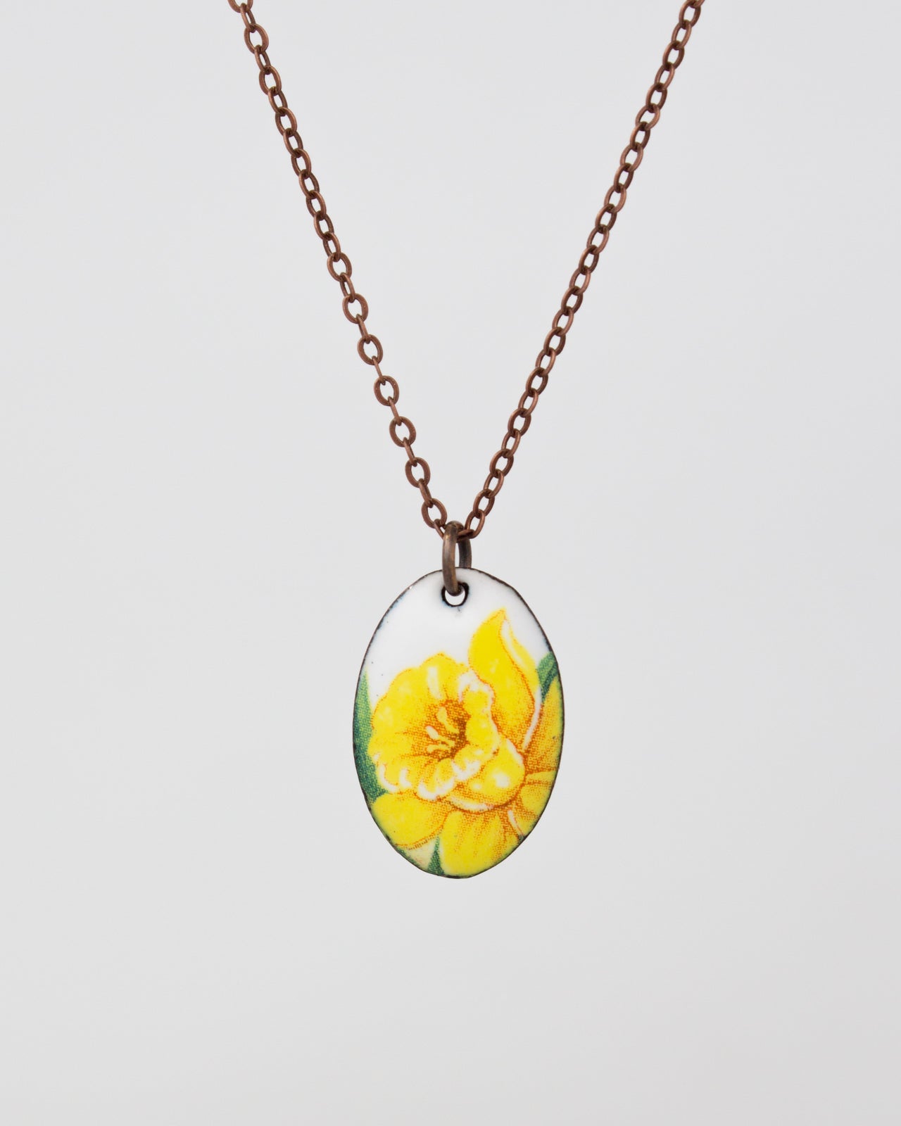 A necklace with a pendant featuring a yellow flower design.