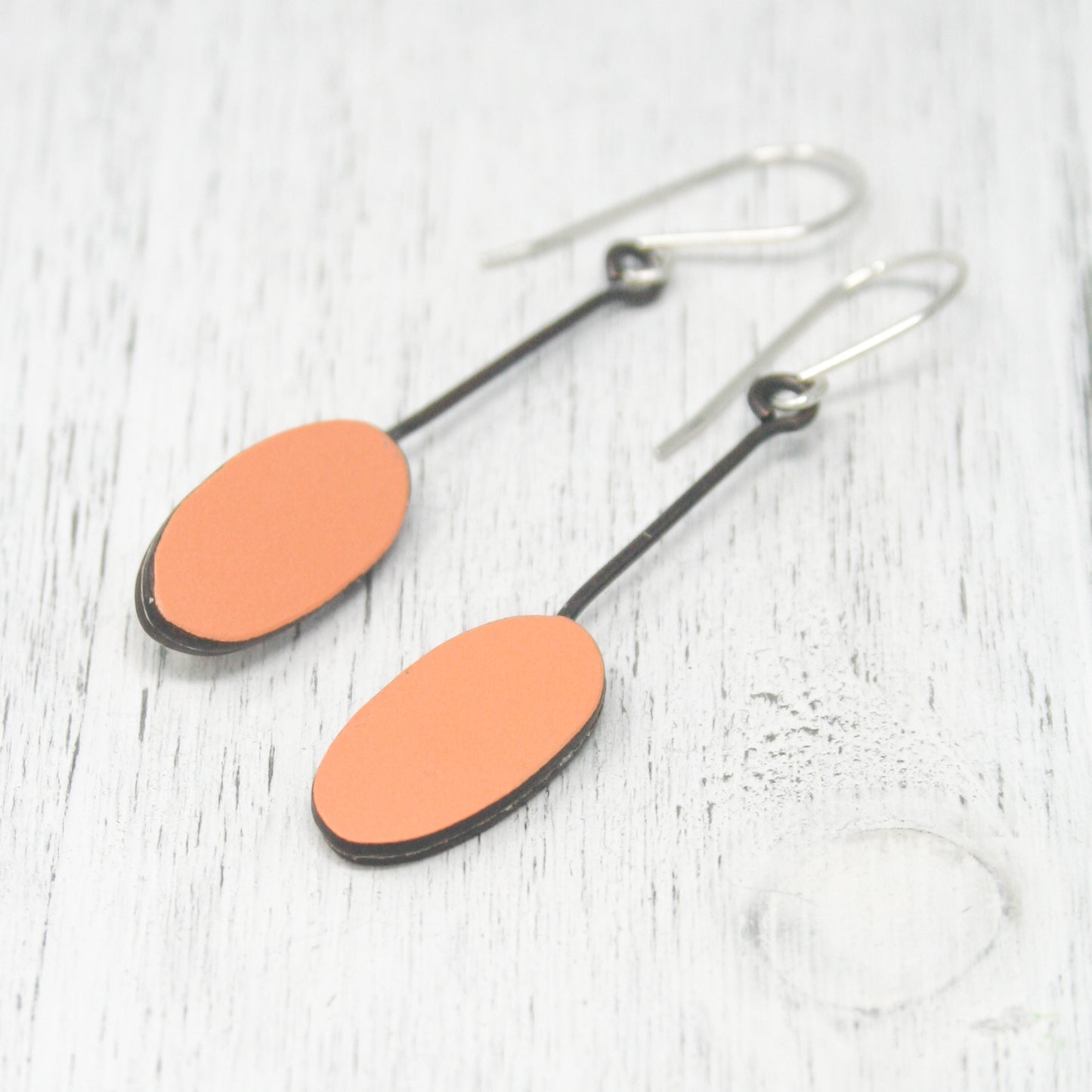 a pair of orange and black oval earrings