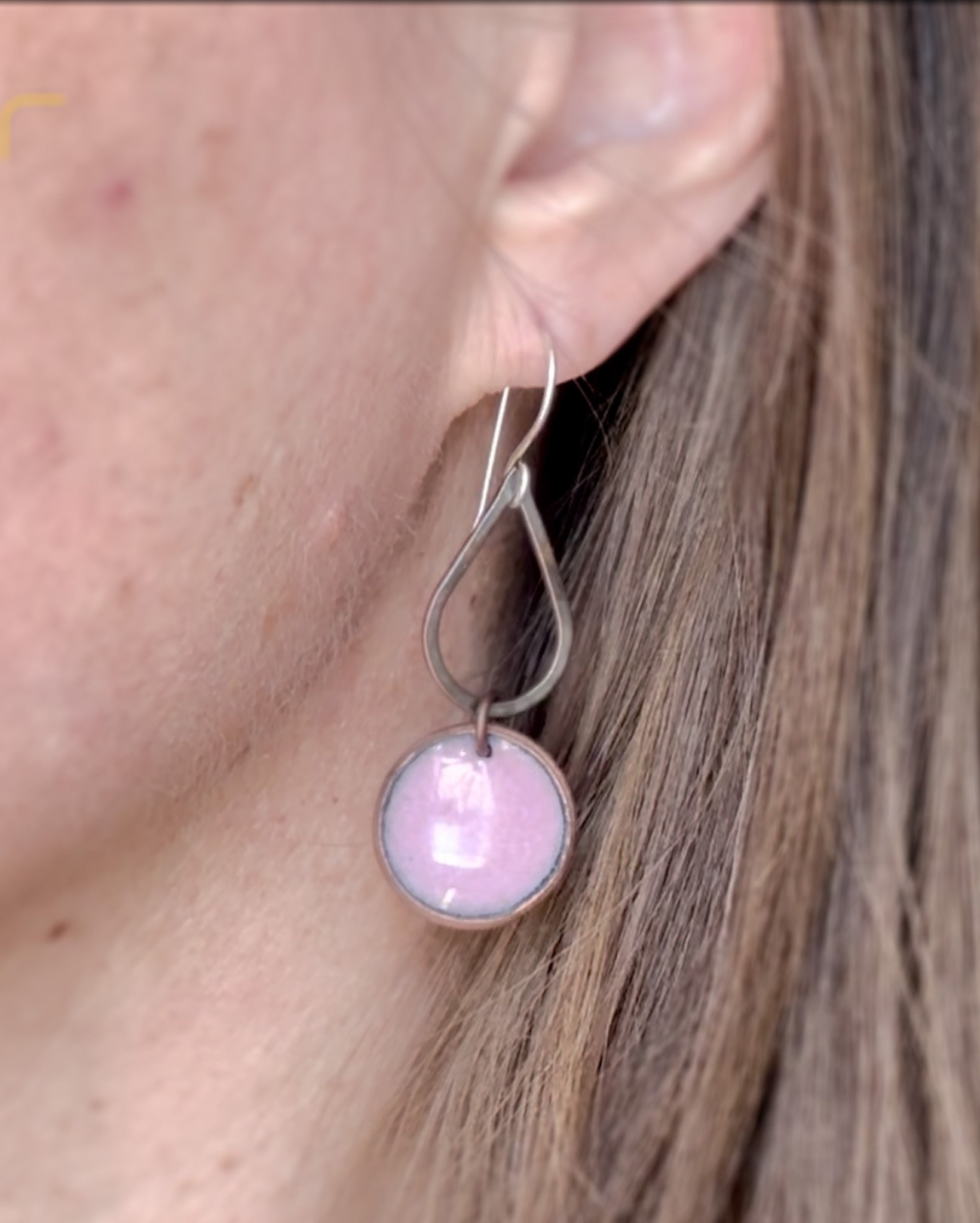 a close up of a person wearing a pair of earrings