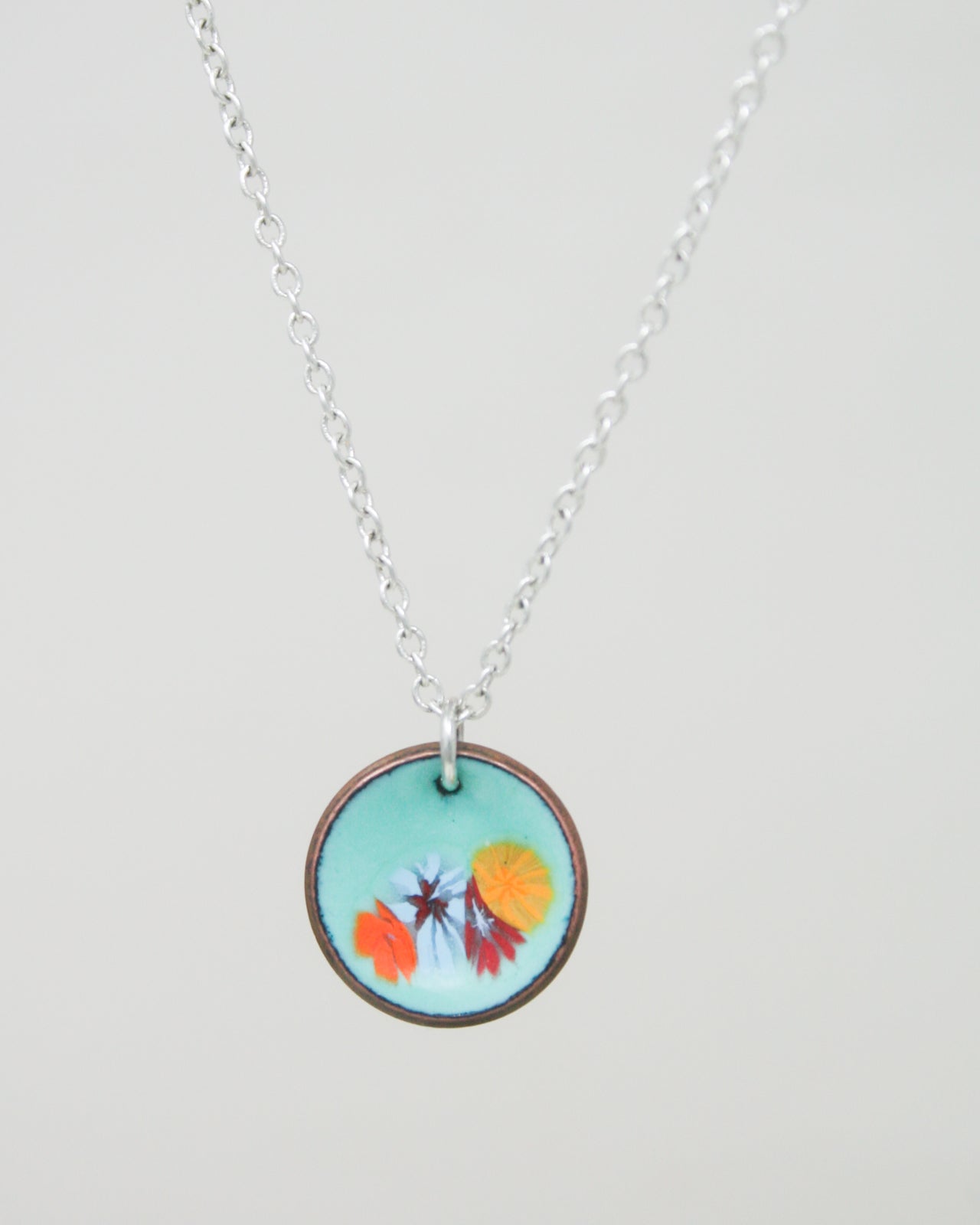 a necklace with a picture of flowers on it