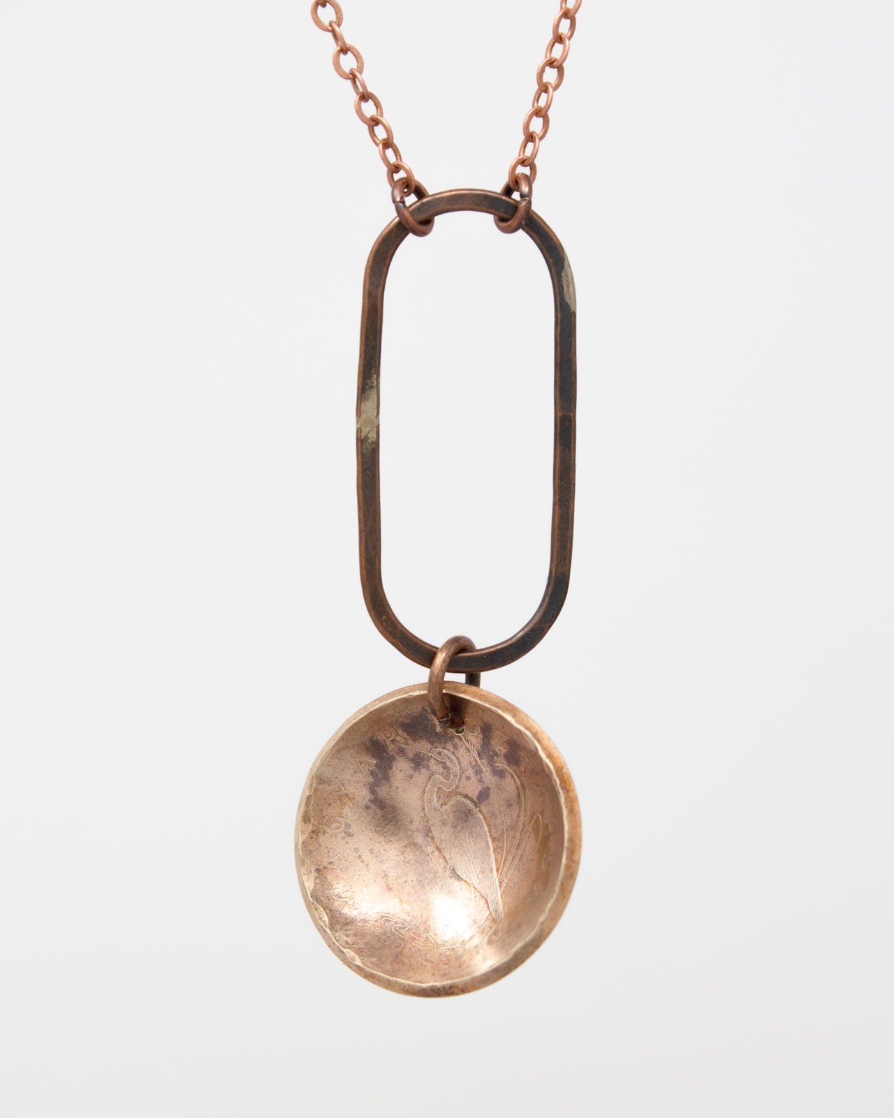 A necklace with a circular pendant featuring a floral design.