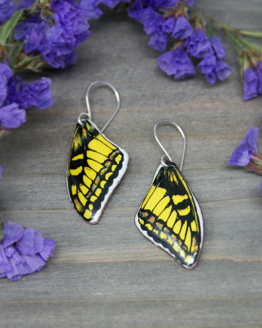 a pair of yellow and black butterfly earrings