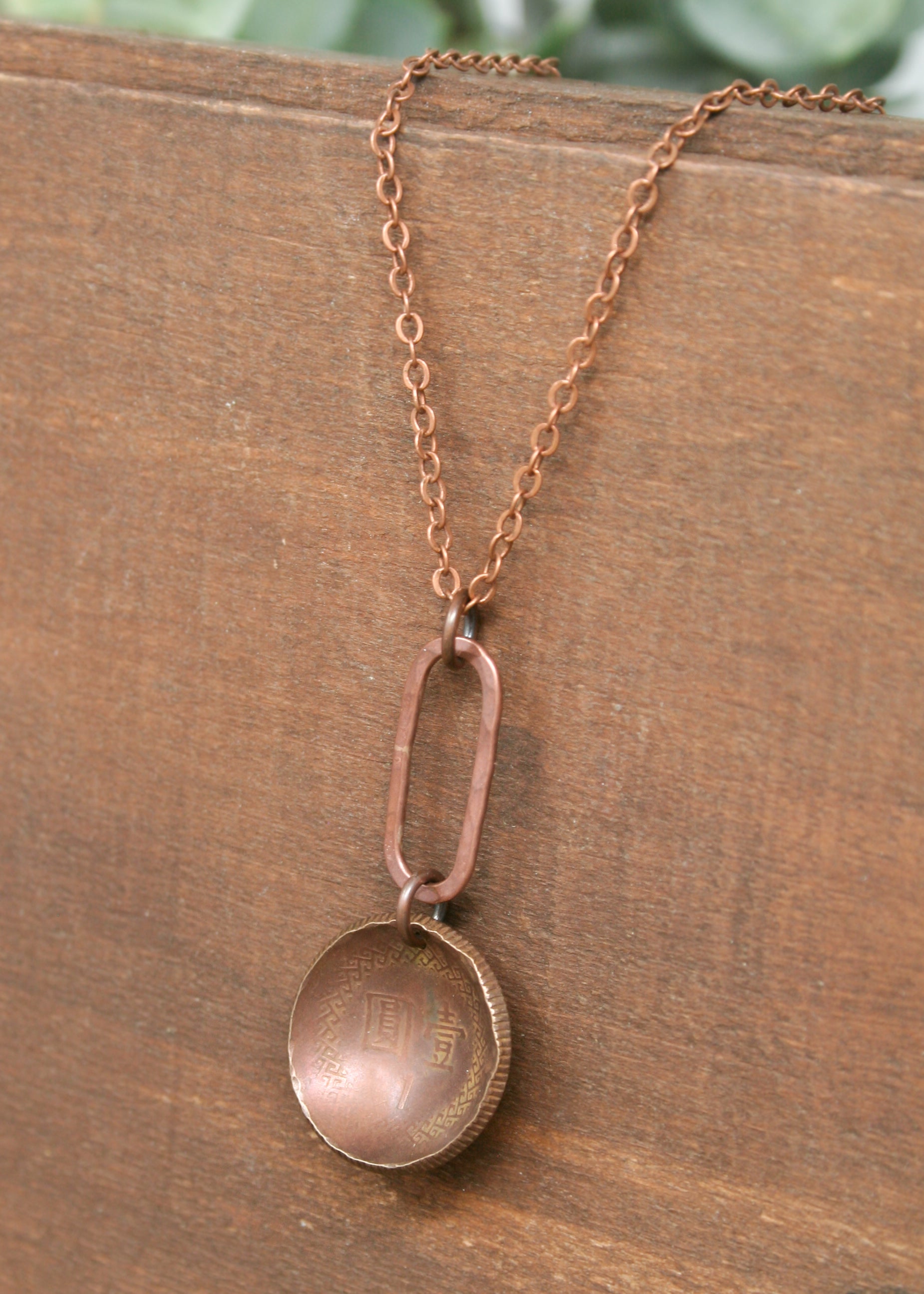 a close up of a necklace on a wooden surface