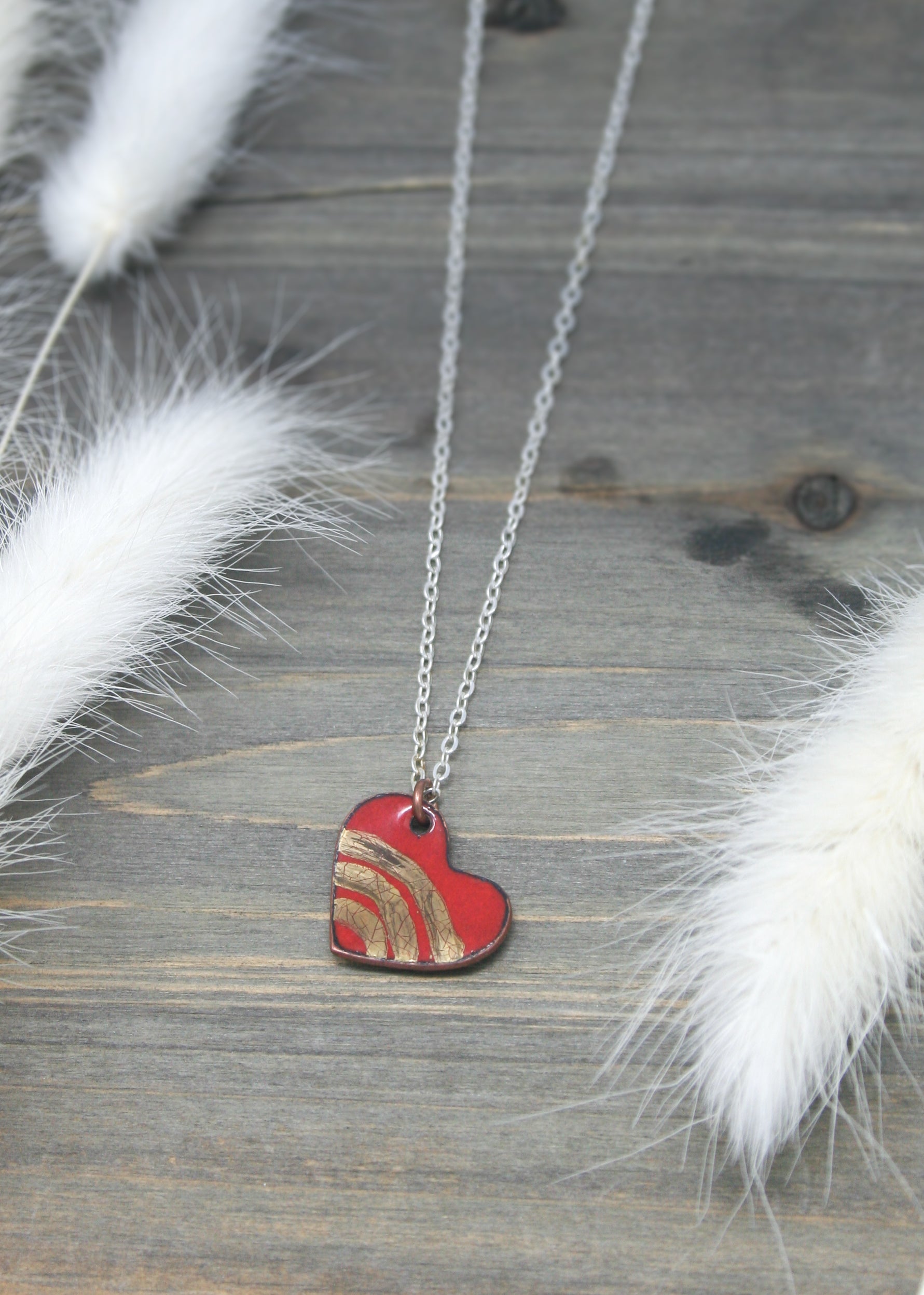 a necklace with a red heart on it