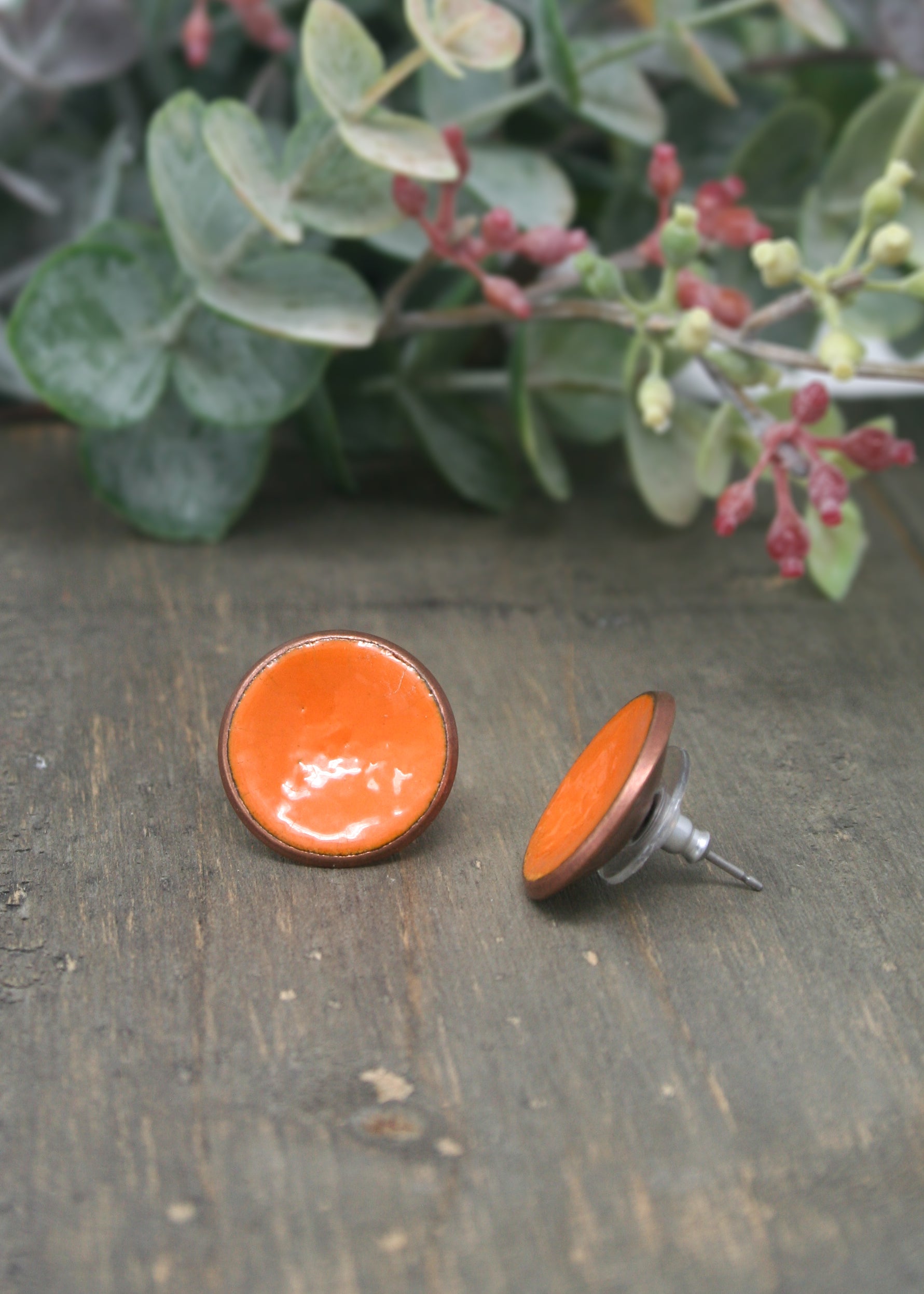 a pair of orange buttons sitting on top of a wooden table