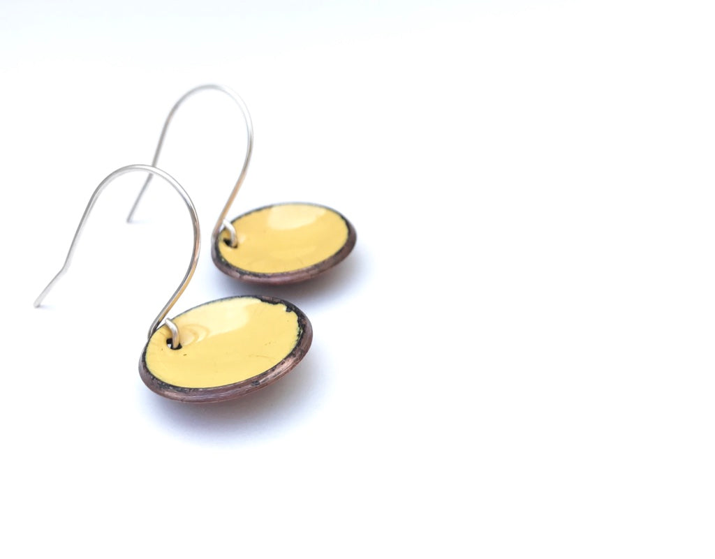 a pair of earrings sitting on top of a white surface