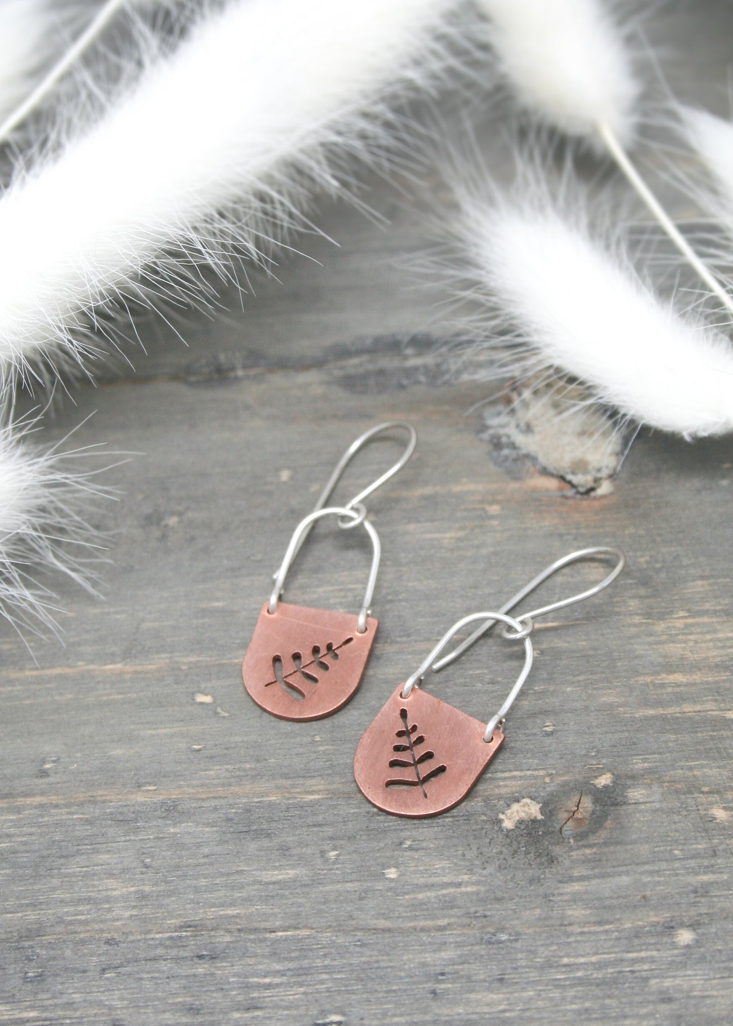 a pair of earrings with a tree on them