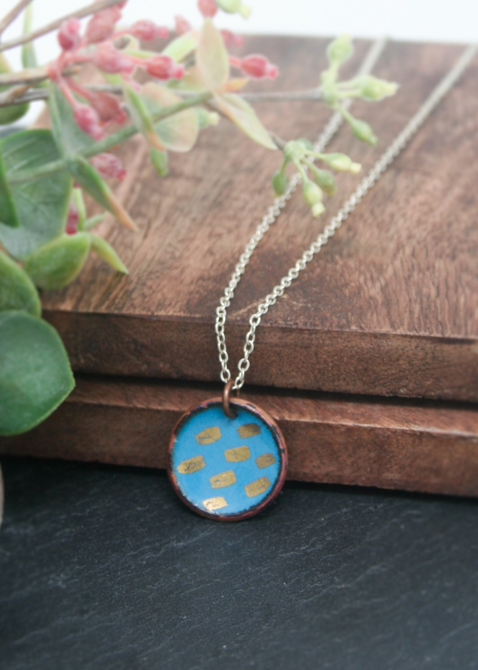 a necklace with a blue and yellow design on it
