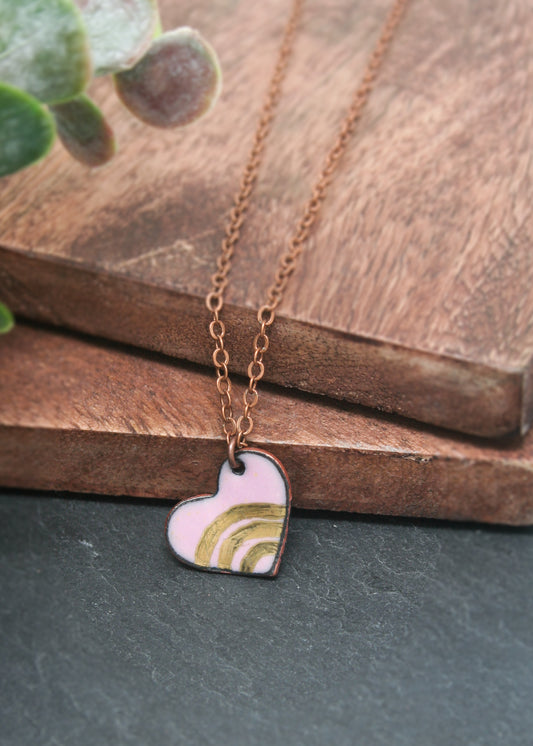 a necklace with a heart shaped pendant hanging from it
