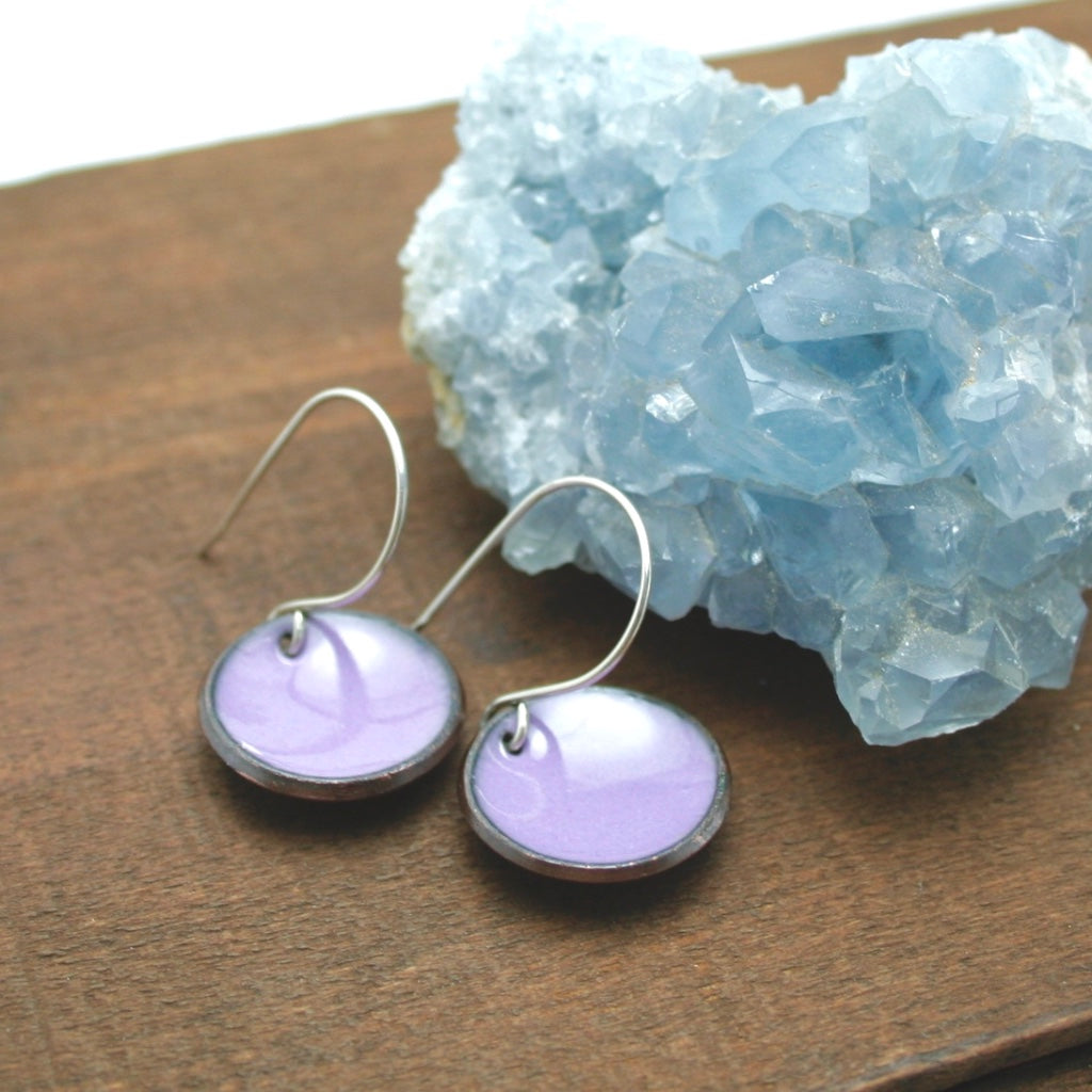 a pair of earrings sitting on top of a wooden table