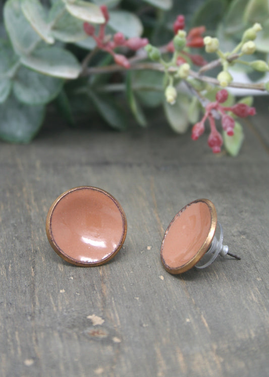 a pair of earrings sitting on top of a wooden table