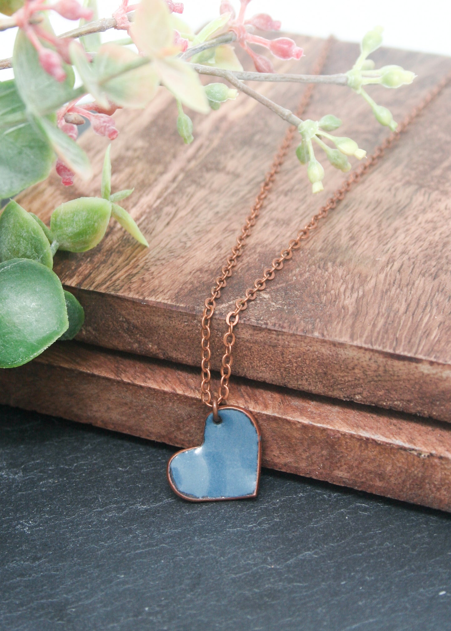 a necklace with a heart on it sitting on a table