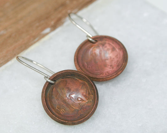 a pair of earrings with a circular design on them