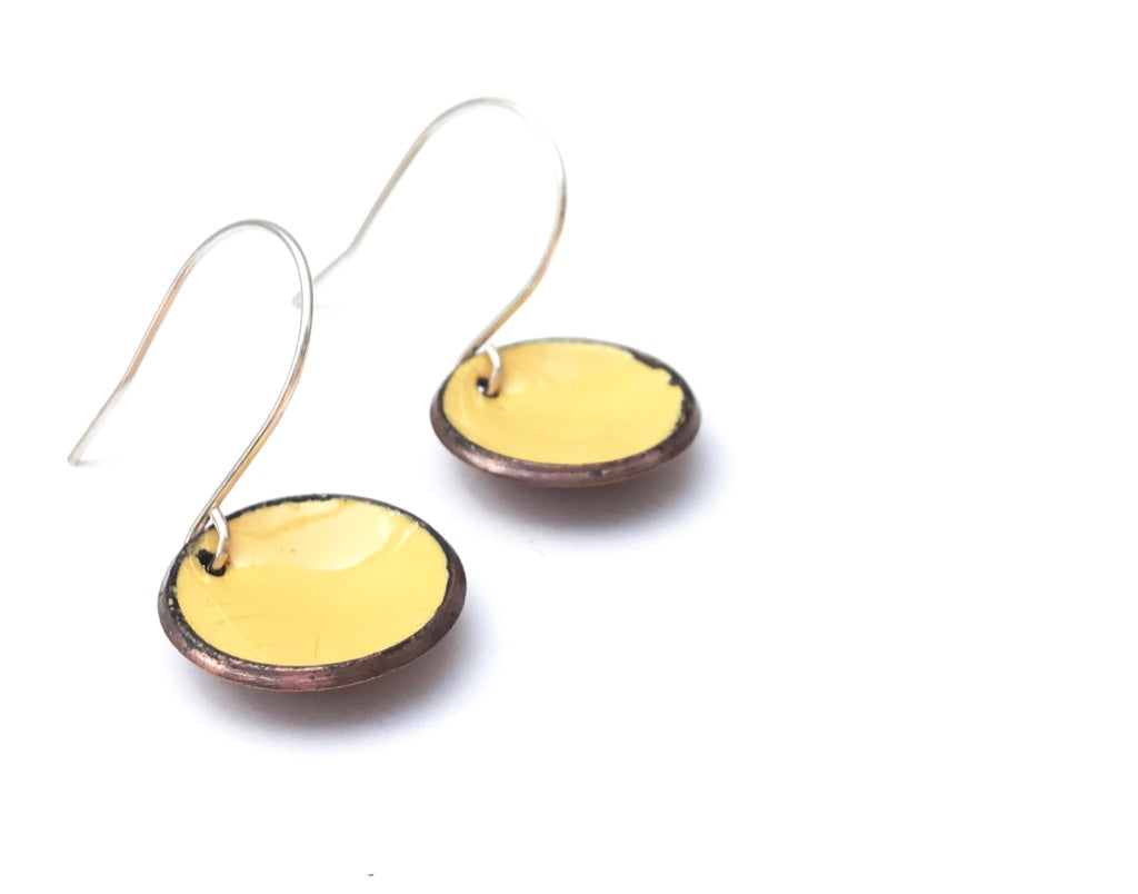 a pair of yellow earrings on a white background