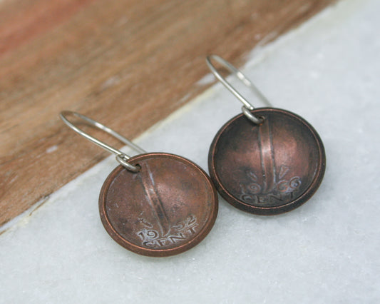 a pair of earrings sitting on top of a wooden floor