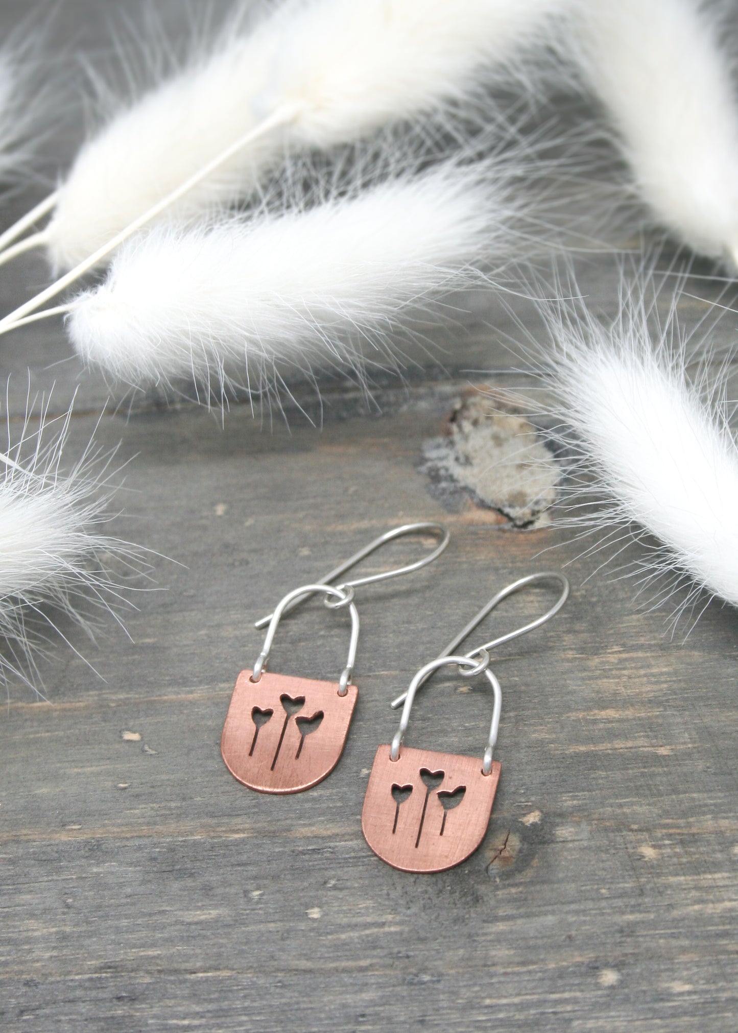 a pair of earrings with a cat on it