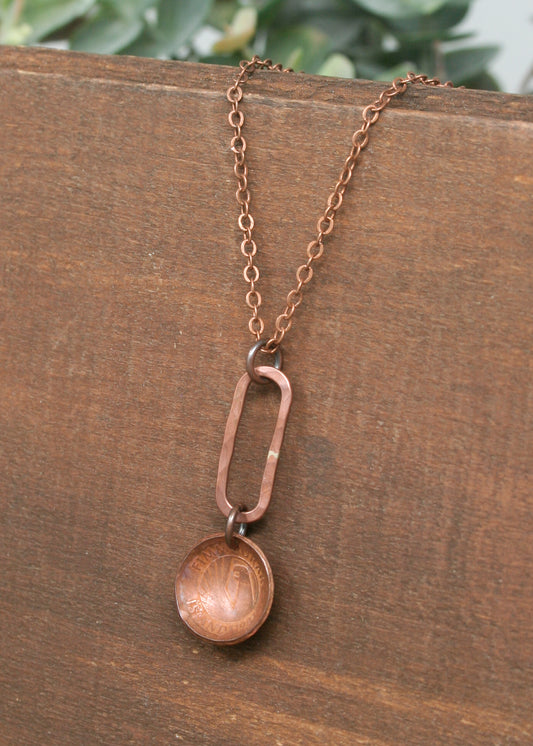 a necklace with a wooden disc hanging from a chain