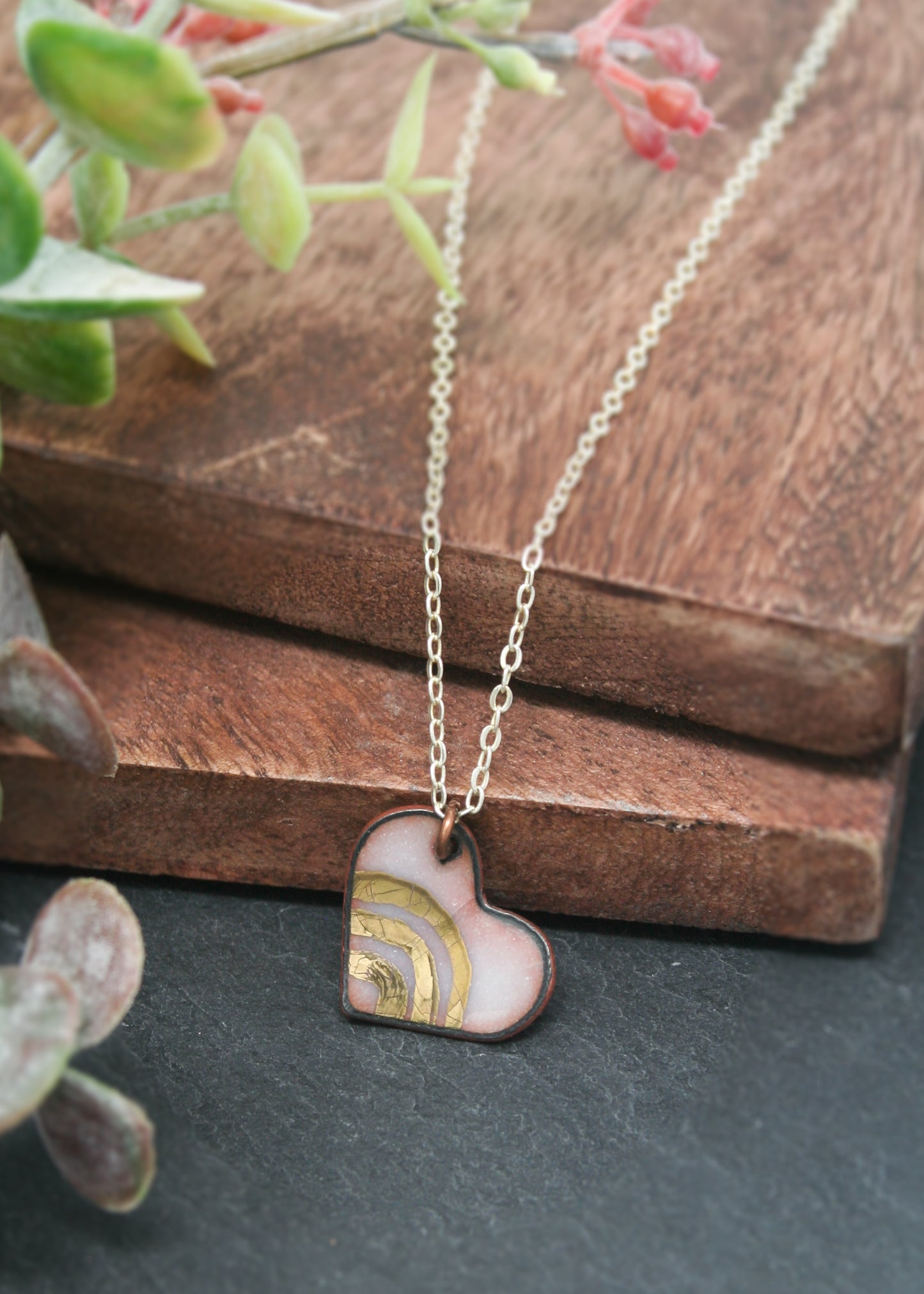 a heart shaped pendant on a wooden surface