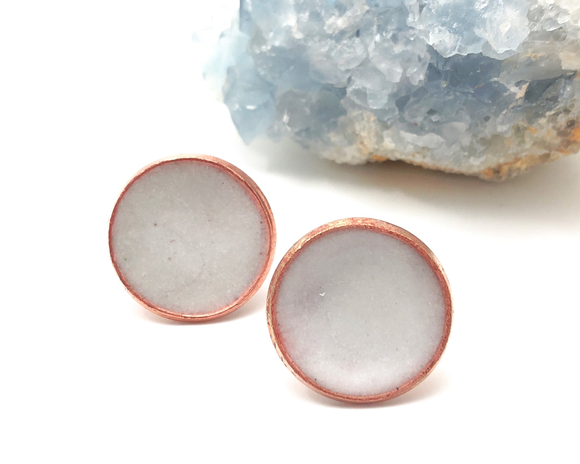 a pair of white and rose gold plated earrings