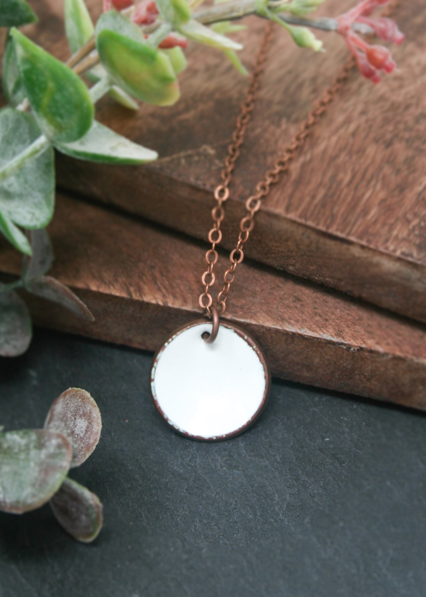 a necklace with a white disc hanging from it