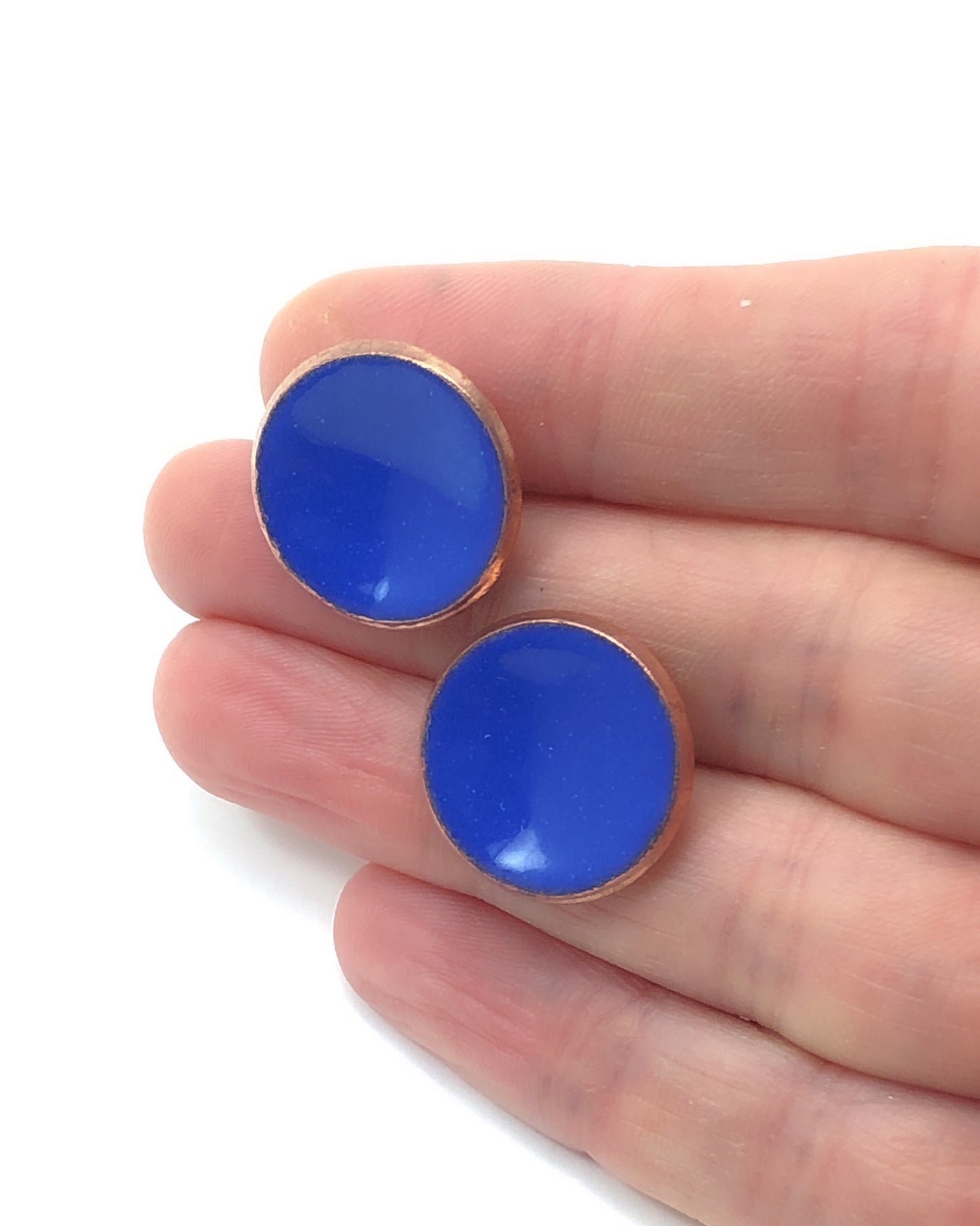 a pair of blue earrings sitting on top of a person's hand