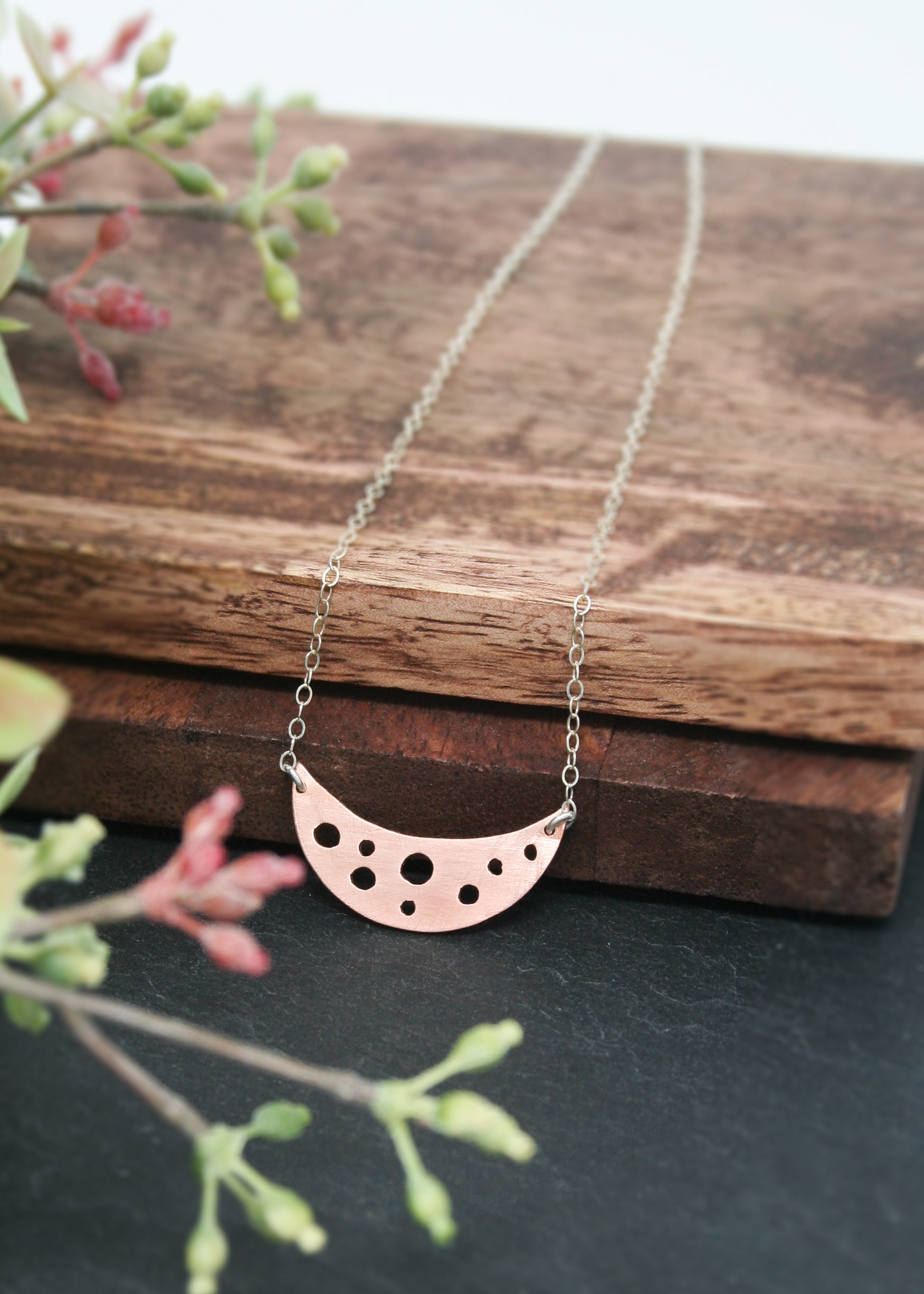 a necklace with a half moon on it
