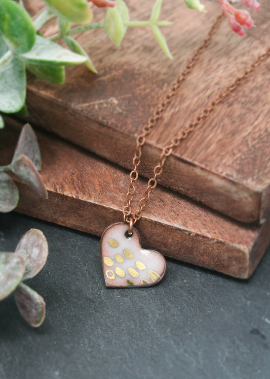 a heart shaped necklace sitting on top of a wooden table