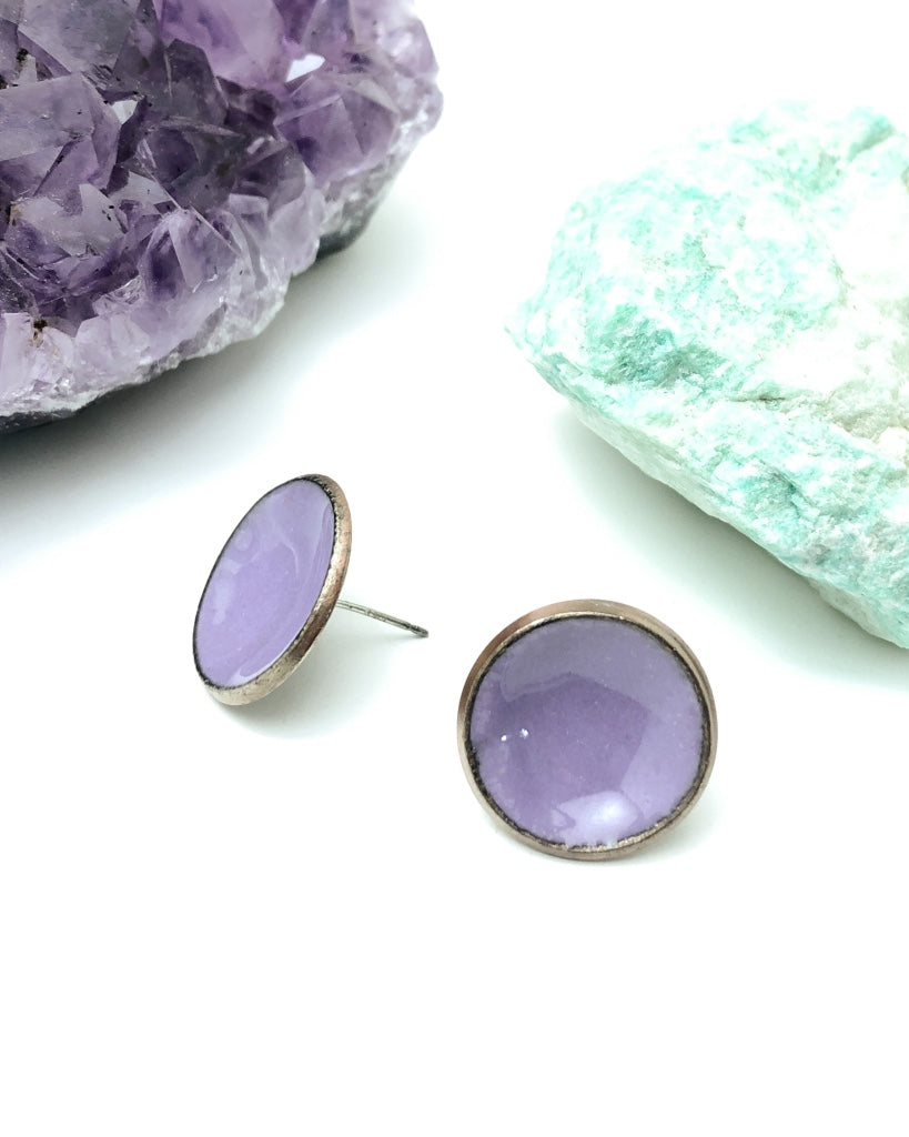 a pair of earrings sitting next to a rock