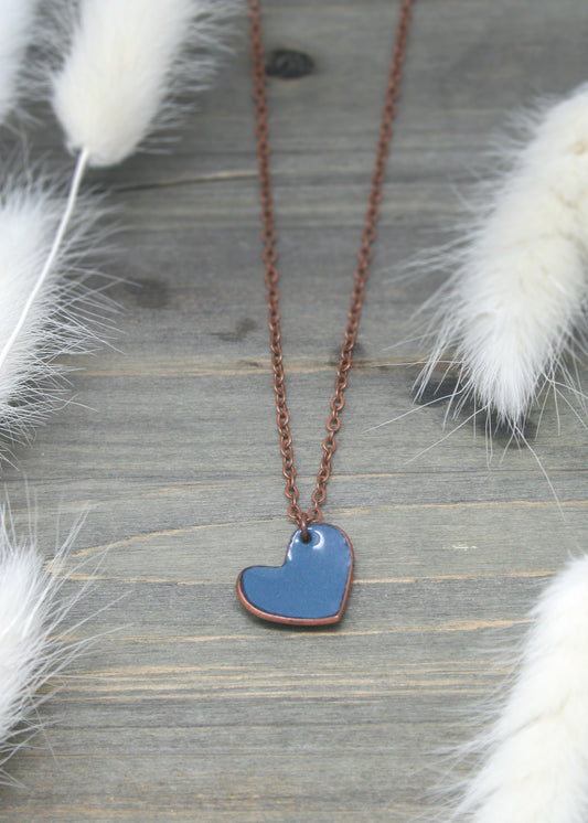 a necklace with a blue heart hanging from it