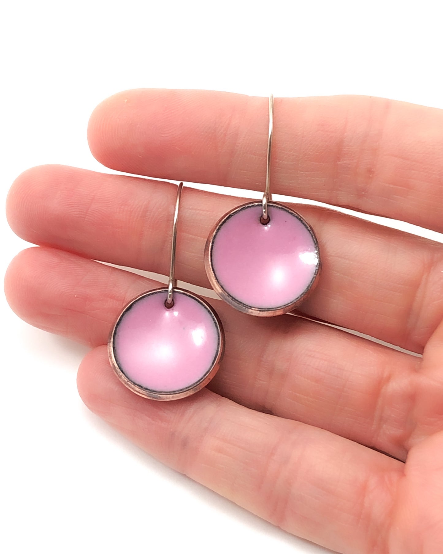 a pair of pink earrings on a person's hand