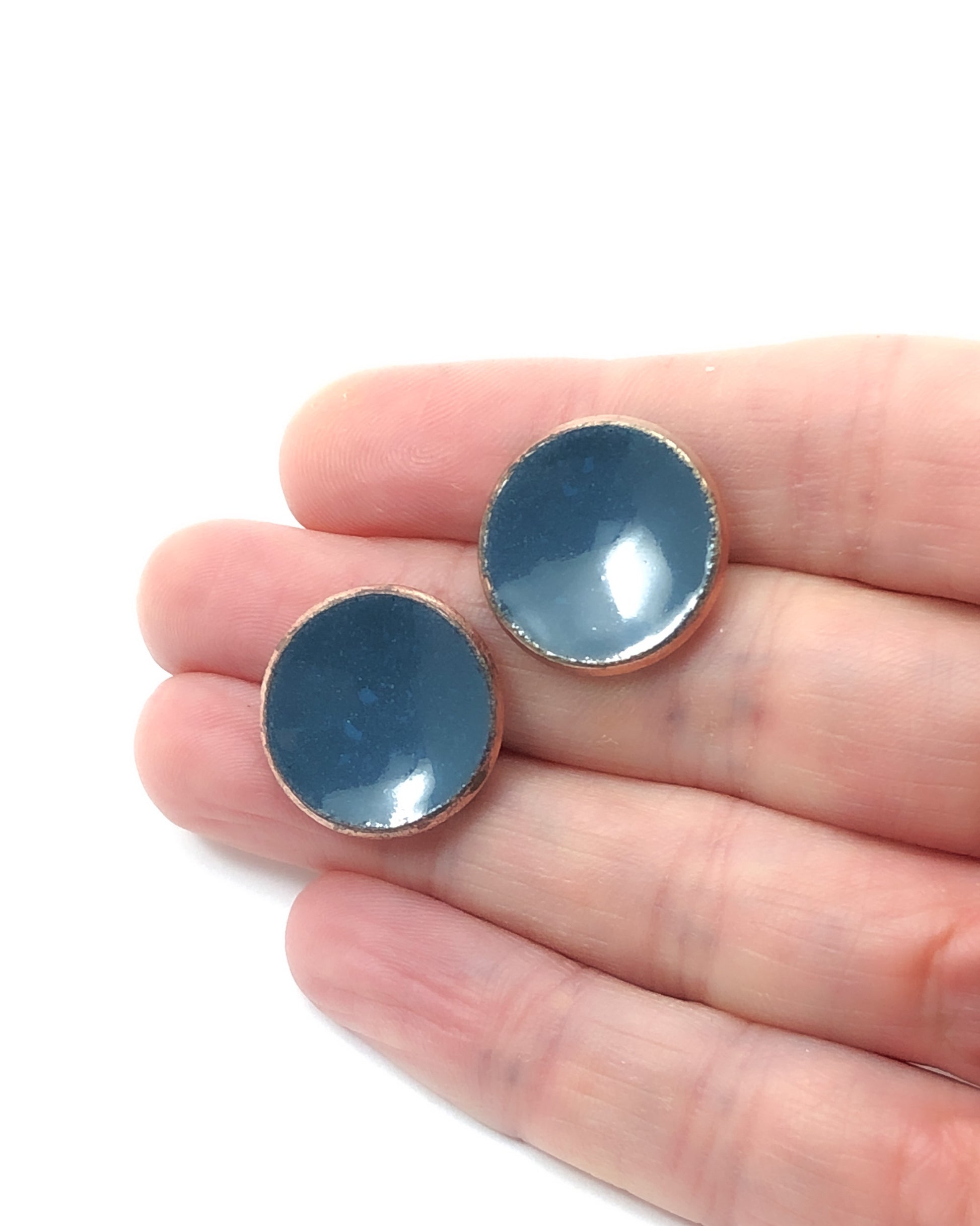 a pair of blue glass cabochons in a hand